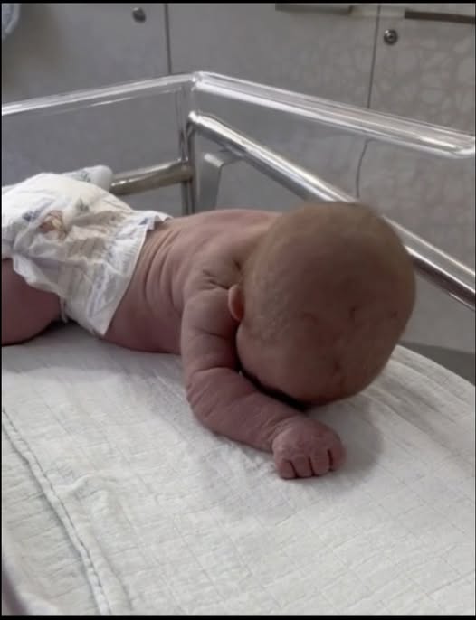 Newborn baby crawls across the hospital cot